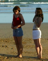 Four girls come to the beach, take off the cloth to stay in bikinis and have fun nude in the water