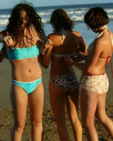 Four girls come to the beach, take off the cloth to stay in bikinis and have fun nude in the water