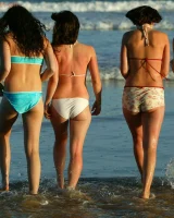 Four girls come to the beach, take off the cloth to stay in bikinis and have fun nude in the water