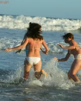 Four girls come to the beach, take off the cloth to stay in bikinis and have fun nude in the water