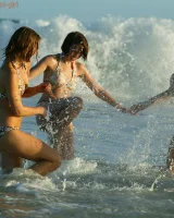 Four girls come to the beach, take off the cloth to stay in bikinis and have fun nude in the water