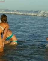 Four girls come to the beach, take off the cloth to stay in bikinis and have fun nude in the water