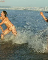 Four girls come to the beach, take off the cloth to stay in bikinis and have fun nude in the water