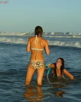 Four girls come to the beach, take off the cloth to stay in bikinis and have fun nude in the water