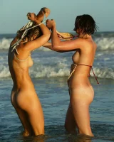 Four girls come to the beach, take off the cloth to stay in bikinis and have fun nude in the water