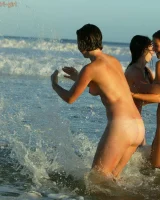 Four girls come to the beach, take off the cloth to stay in bikinis and have fun nude in the water