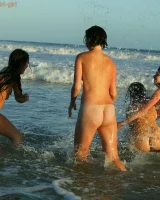 Four girls come to the beach, take off the cloth to stay in bikinis and have fun nude in the water