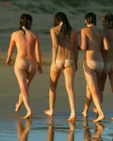 Four girls come to the beach, take off the cloth to stay in bikinis and have fun nude in the water