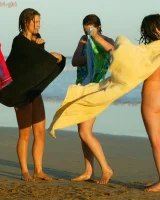 Four girls come to the beach, take off the cloth to stay in bikinis and have fun nude in the water