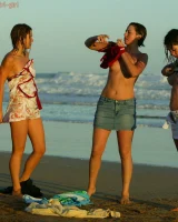 Four girls come to the beach, take off the cloth to stay in bikinis and have fun nude in the water