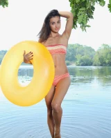 Young brunette Benita B shows her naked body and yummy pussy in an innertube