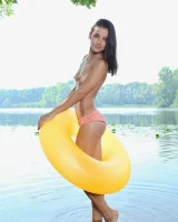 Young brunette Benita B shows her naked body and yummy pussy in an innertube