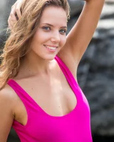 Adorable teen Clover removes her 1 piece swimsuit to pose nude on rocks