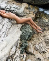 Adorable teen Clover removes her 1 piece swimsuit to pose nude on rocks