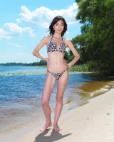 Thin girl Malvina takes off her bikini to pose nude on a beach towel