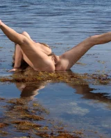 Busty Rubie in pink motley bikini is going nude at the sea on the rocks with unshaven vagina