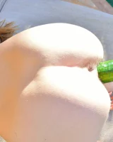 Teen lesbians Romi and Raylene stuff cucumbers into each others twat on poolside lounge chairs