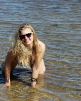 Hairy pussy Gretel in bikini going nude outside in the water to have her nipples puffy