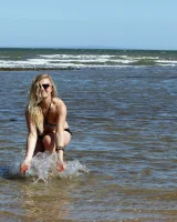 Hairy pussy Gretel in bikini going nude outside in the water to have her nipples puffy