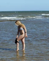 Hairy pussy Gretel in bikini going nude outside in the water to have her nipples puffy