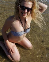 Hairy pussy Gretel in bikini going nude outside in the water to have her nipples puffy