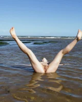 Hairy pussy Gretel in bikini going nude outside in the water to have her nipples puffy