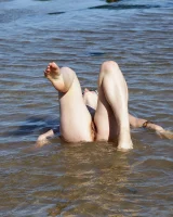 Hairy pussy Gretel in bikini going nude outside in the water to have her nipples puffy