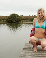 Blonde Melaina in green bikini flashing in the pier