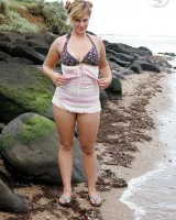 Nora is in the bikini and nude on the beach