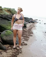 Nora is in the bikini and nude on the beach