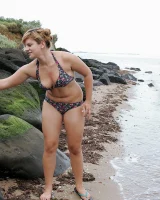 Nora is in the bikini and nude on the beach