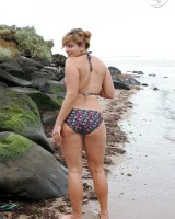 Nora is in the bikini and nude on the beach