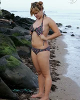 Nora is in the bikini and nude on the beach