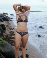 Nora is in the bikini and nude on the beach