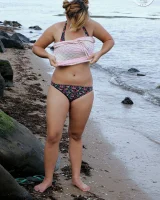 Nora is in the bikini and nude on the beach