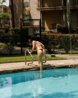 Busty latin baby Adriene Macedo is in the pool in sexy dark red bikini