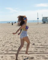 Tits flashing playful busty Elizabeth Marxs has fun on the beach in motley bikini