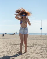 Tits flashing playful busty Elizabeth Marxs has fun on the beach in motley bikini