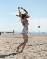 Tits flashing playful busty Elizabeth Marxs has fun on the beach in motley bikini