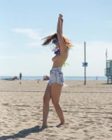 Tits flashing playful busty Elizabeth Marxs has fun on the beach in motley bikini