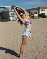 Tits flashing playful busty Elizabeth Marxs has fun on the beach in motley bikini