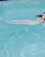 Redhead beauty Emily Archer visiting pool in sexy red and white bikini