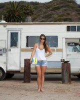 Beach volleyball player Eva Lovia in sexy orange and blue bikini