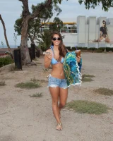 Beach volleyball player Eva Lovia in sexy orange and blue bikini