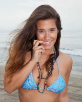 Beach volleyball player Eva Lovia in sexy orange and blue bikini