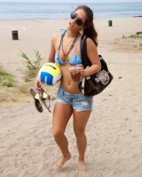 Beach volleyball player Eva Lovia in sexy orange and blue bikini