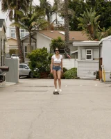Busty chick Jade Baker is sexy skateboarder in cut tiny jeans shorts and fantastic baby in black bikini on the beach