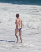 Sweet brunette Natalie Moore is sexy in the sea and on the beach wearing blue and pink bikini