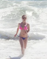 Sweet brunette Natalie Moore is sexy in the sea and on the beach wearing blue and pink bikini