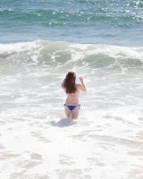 Sweet brunette Natalie Moore is sexy in the sea and on the beach wearing blue and pink bikini